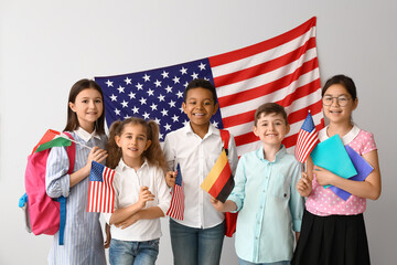 Pupils of language school near light wall with USA flag