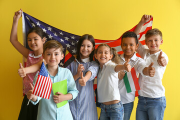 Pupils of language school with different flags showing thumb-up on color background