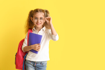 Little school girl on color background