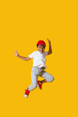 Fototapeta na wymiar Dancing African-American boy on color background