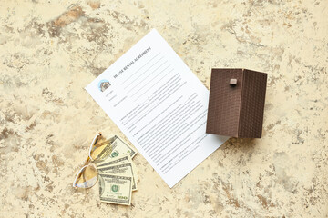 House rental agreement with eyeglasses, banknotes and toy on grunge background