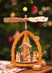 Traditional christmas pyramid in front of a Christmas tree