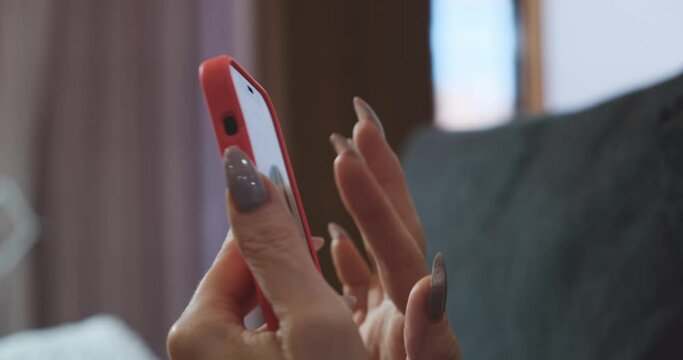 Selective focus. Womens hands scroll through the Internet pages on the phone. A woman with a phone. The concept of online shopping in a store, social media networks. Lifestyle during lockdown and pand