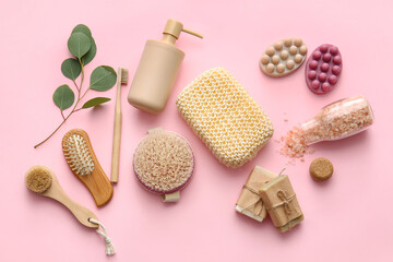 Obraz na płótnie Canvas Set of bath supplies with loofah sponge and plant branch on pink background