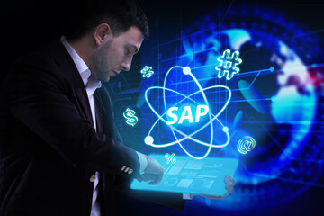 Business, Technology, Internet and network concept. Young businessman working on a virtual screen of the future and sees the inscription: SAP