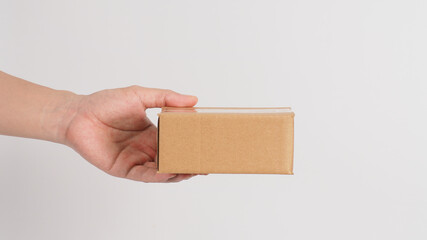 Hand is holding brown box isolated on white background.