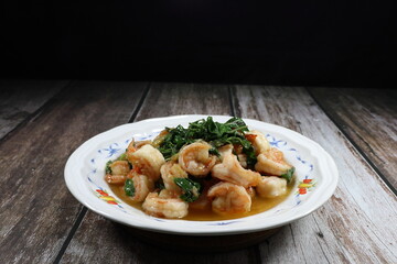 Famous spicy fried fresh peeled shrimp with hot basil and chilly serving on the plate. 