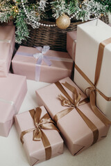 Christmas gifts in pink packaging with a bow on the background of the Christmas tree