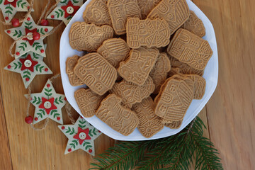 Traditional cookies from northern europe called Speculoos on wooden table. Festive cookies made with spices with festive decorations