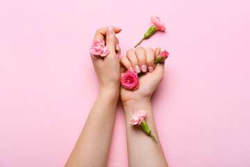 Female hands with beautiful manicure and flower buds on color background
