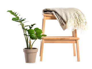 Wooden step stool with plaid and houseplant on white background