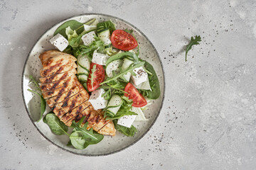 Grilled chicken breast. Fried chicken fillet and fresh vegetable salad with tomatoes, cucumber and...