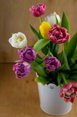 Mix of spring tulips flowers. Bouquet in a vase. Multi-colored spring flower. Gift. Red, pink, white and yellow. Background with flowers tulips close-up different colors.