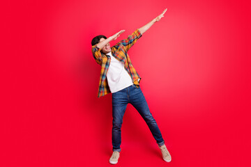 Photo of sweet funny young gentleman wear plaid outfit smiling dancing isolated red color background