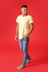 Fototapeta premium Handsome young man in stylish t-shirt on color background