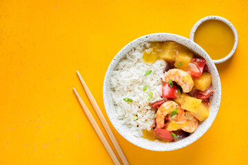 Shrimps pineapple rice in a bowl, asian cuisine food. Yellow background, top view