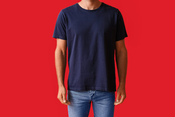 Handsome young man in stylish t-shirt on color background