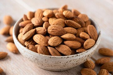 Almonds in bowl on a wooden table with copy space. Healthy vegan food