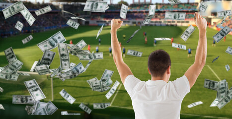online betting, gambling and sport concept - happy man with raised hands and money rain over...