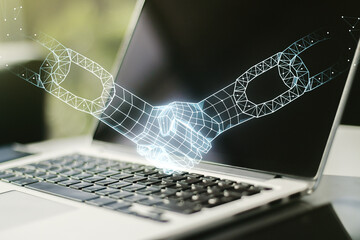 Creative concept of blockchain technology with handshake on modern laptop background. digital money...