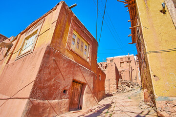 The steep ascent street in medieval mountain village with red adobe houses on both sides, Abyaneh,...