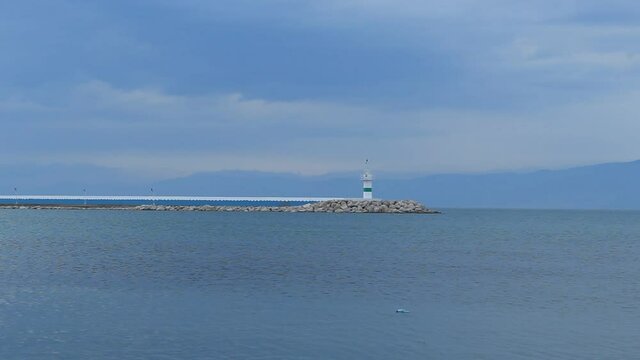 Port marina harbor. Ship in the sea. Signal tower in port. Video taken in iskele burhaniye balikesir aegean sea coast line turkey anatolia asia. Calm cloudy rainy weather day in winter december 2021