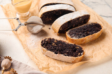 Cut poppy seed strudel on white marble background