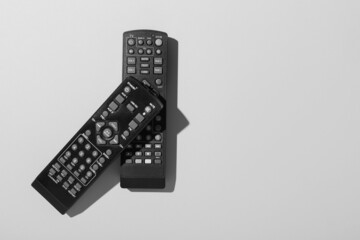 Black TV remote controllers on grey background