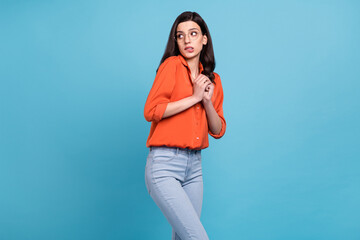 Portrait of attractive scared shy girl biting lip looking aside copy space isolated over bright blue color background