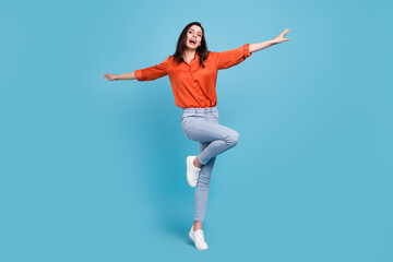 Fototapeta na wymiar Full length body size view of attractive cheerful girl flying like plane having fun isolated over bright blue color background