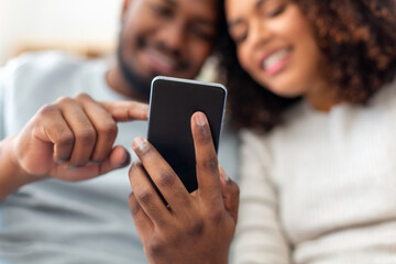 technology, internet and people concept - close up of happy couple with smartphone at home