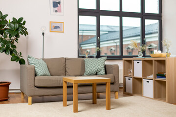 comfort, furniture and interior concept - sofa with cushions at cozy home living room
