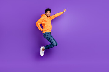 Fototapeta na wymiar Full length photo of young brunet haired dark skin man jump up dream empty space fly isolated on purple color background