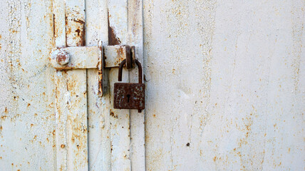 background of very old metal rusty grey garage door with handle and barn lock