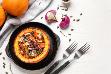 Frying pan with tasty stuffed pumpkin on white wooden background