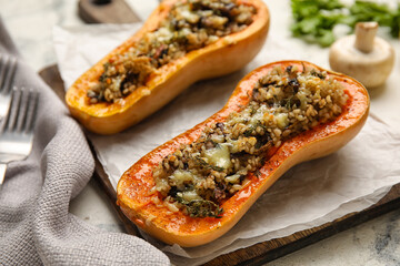 Wooden board with tasty stuffed pumpkins on table