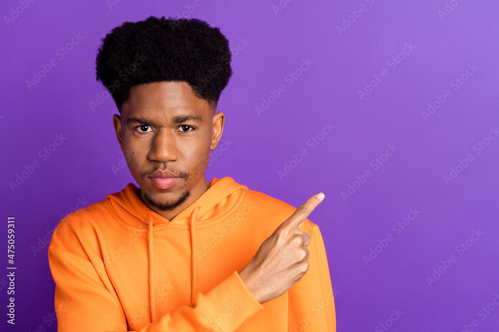 Wall mural Photo of young serious dark skin cool man point finger empty space news sale isolated on violet color background - Wall murals
