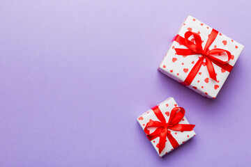 Valentine day composition: red gift box with bow and heart. Christmas present. View from above. Space for text. Holday greeting card