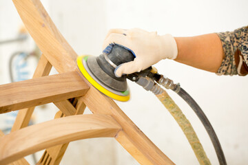Sanding furniture. Grinding machine close-up in the process. Sanding wooden furniture.