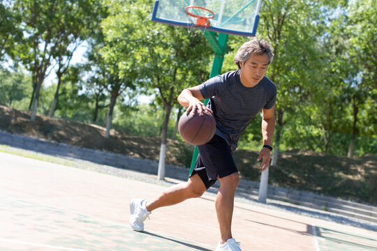 Mature man playing basketball outdoors