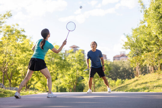 Happy mature couple playing badminton outdoors
