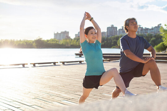 Happy Mature Couple Exercising In Park