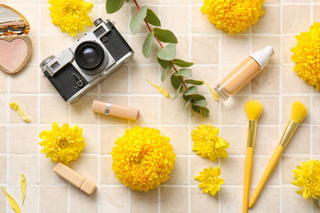 Decorative cosmetics, retro photo camera and yellow chrysanthemum flowers on light background