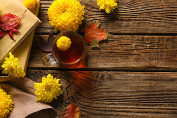 Cup of tea, books and yellow chrysanthemum flowers on wooden background