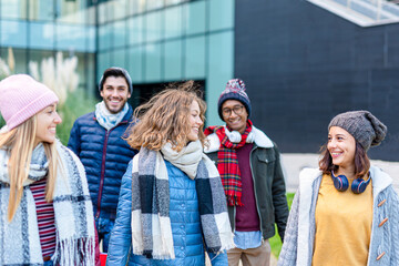 happy women walking with their boyfriends on background, group of millennial friends having fun in the city, cool attitude and trendy clothes