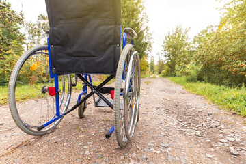 Empty wheelchair standing on road waiting for patient services. Wheel chair for people person with...