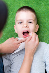 Woman speech therapist helps a boy correct the violation of his speech