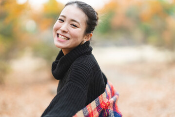 紅葉の公園で遊ぶ女性