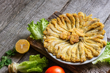 Cooked haddock fishes with cornflour in plate on rustic table