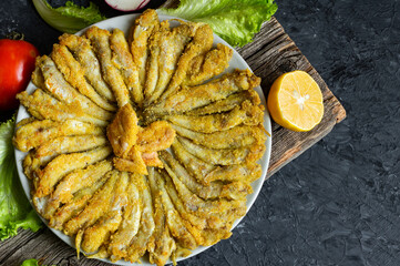 Cooked haddock fishes with cornflour in plate on rustic table